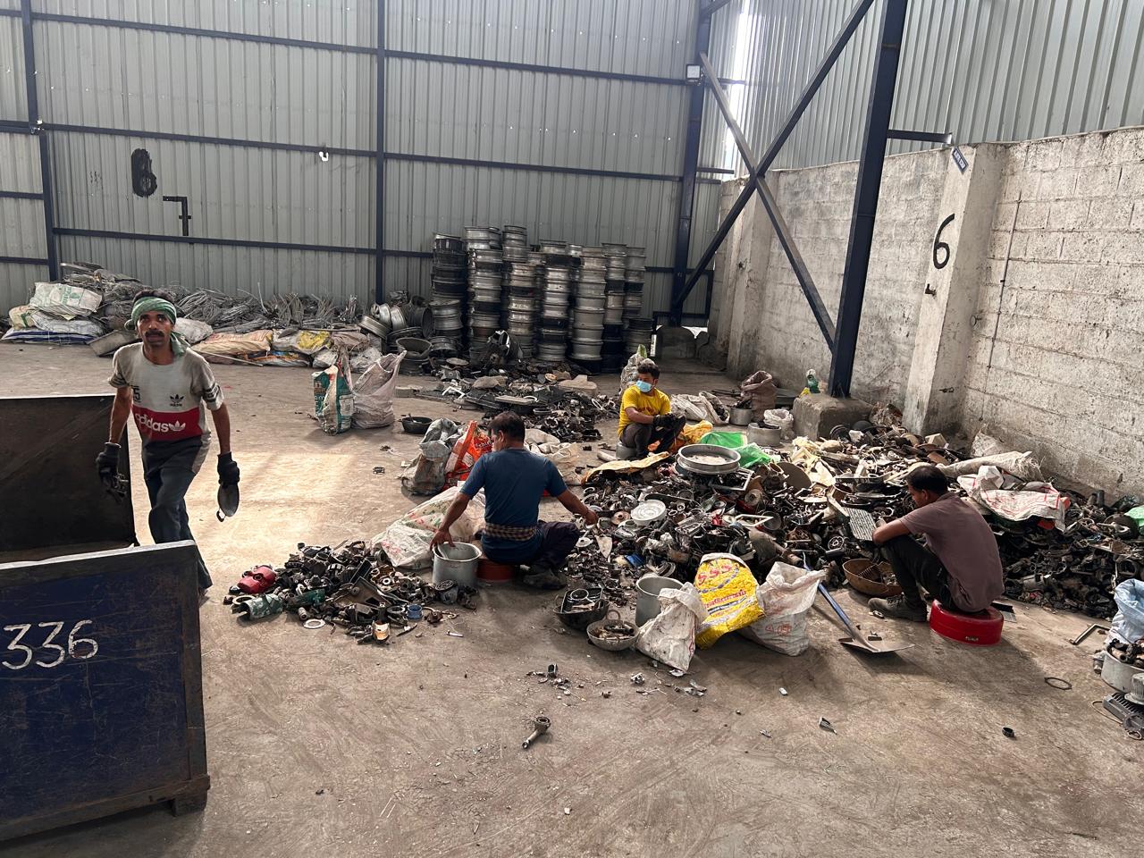Workers manually sorting scrap by alloy grade in the yard